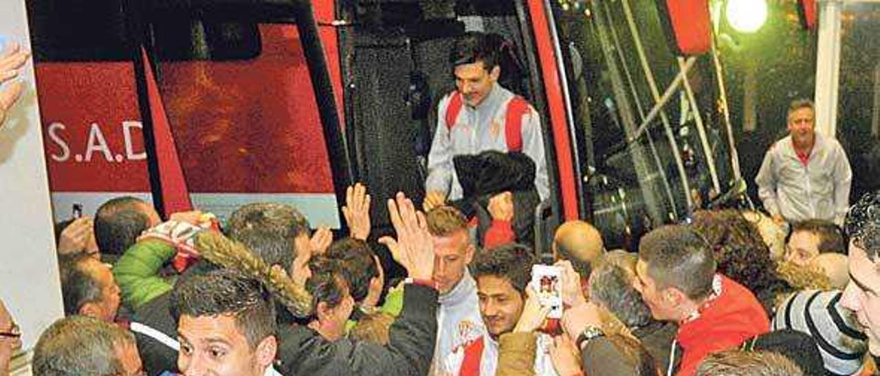 Aficionados del Sporting reciben a los jugadores en un desplazamiento.