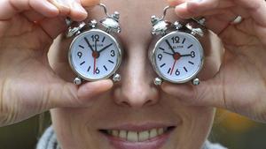 Una empleada del fabricante de relojes Carlton sostiene dos despertadores de la empresa para recordar sobre el cambio de hora.