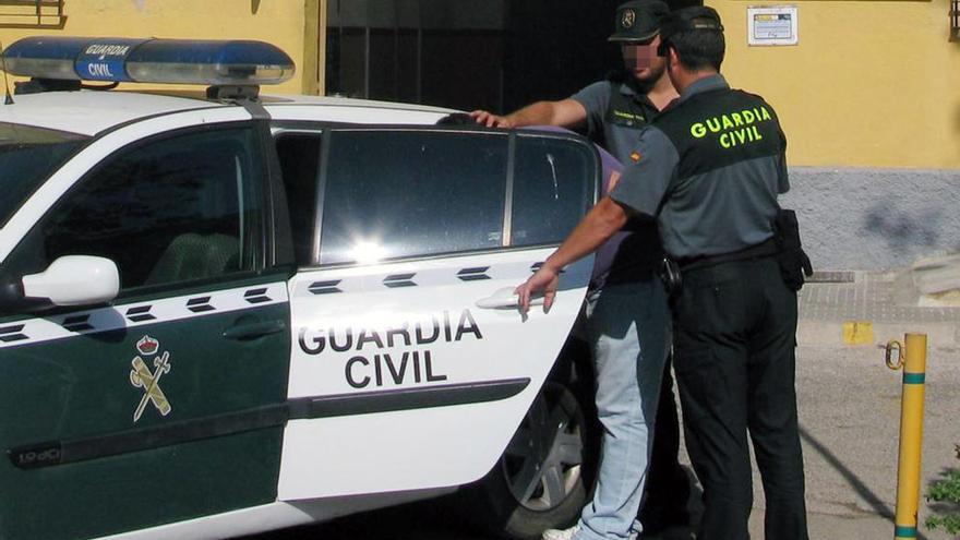 El arrestado siendo introducido en el coche patrulla