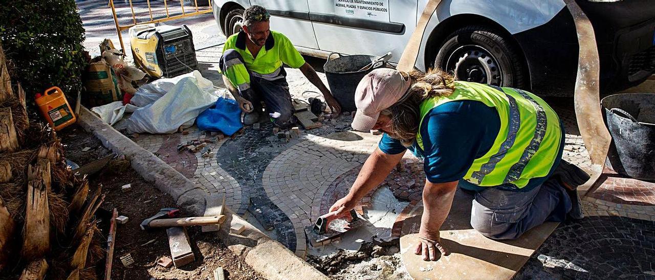 Trabajos en dos de las zonas con «calvas» en el paseo de la Explanada de Alicante.  | RAFA ARJONES