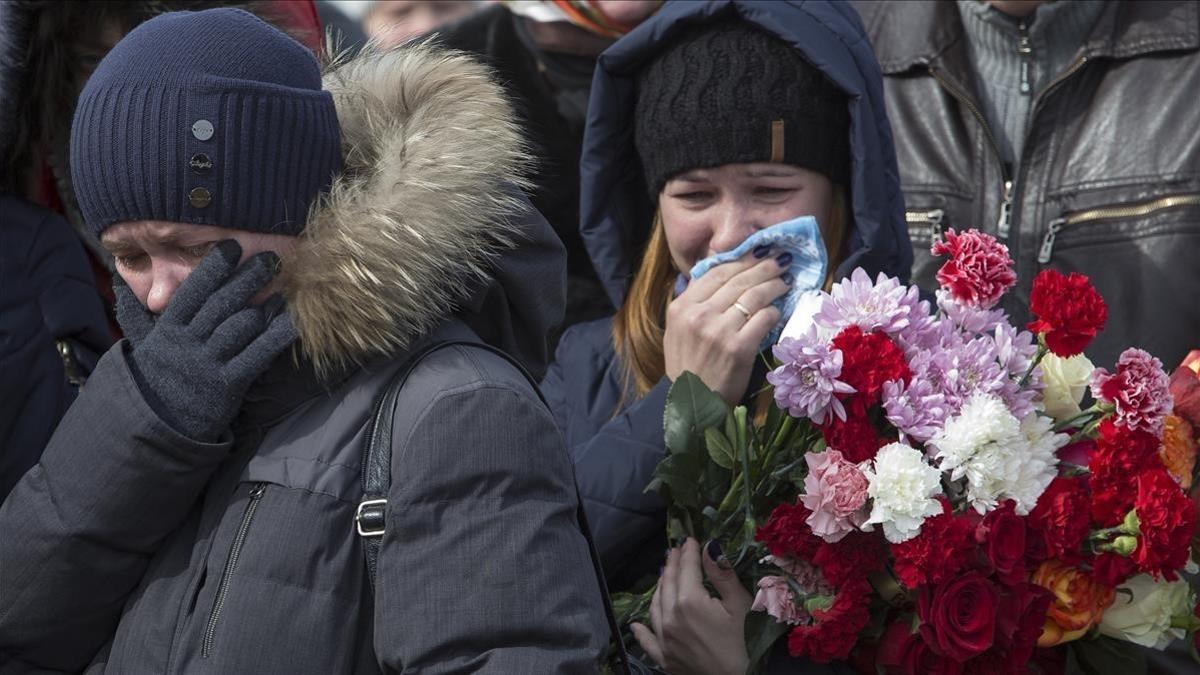 Familiares de dos niños y su abuela fallecidos en el incendio, en el funeral oficiado en Kémerovo (Siberia occidental), el 28 de marzo.