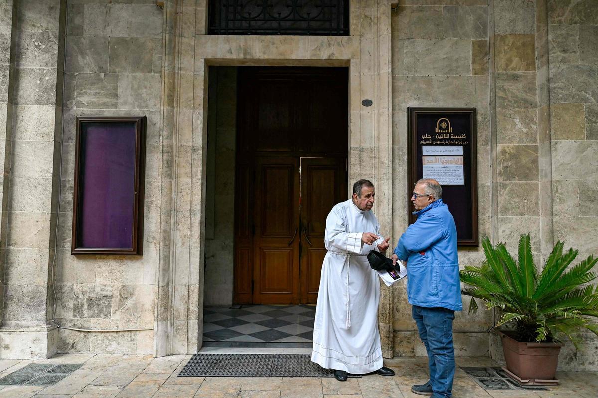 Dos miembros de la iglesia de San Francisco de Asís de Alepo conversan tras un servicio religioso.