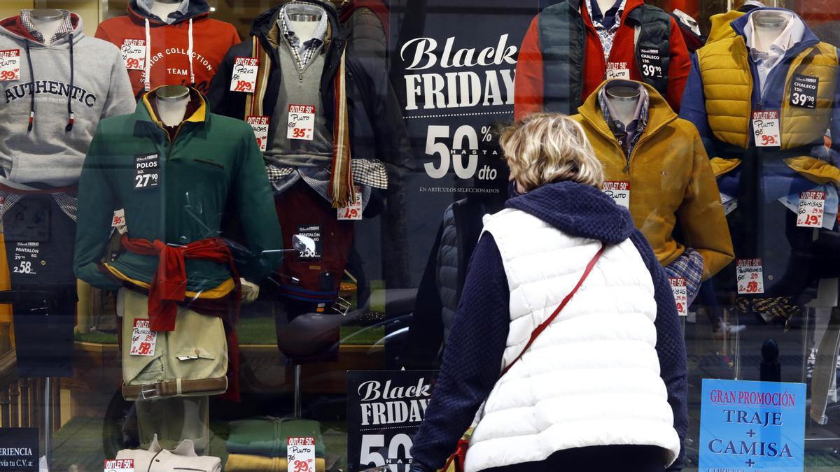 Una mujer mira un escaparate de una tienda de ropa.