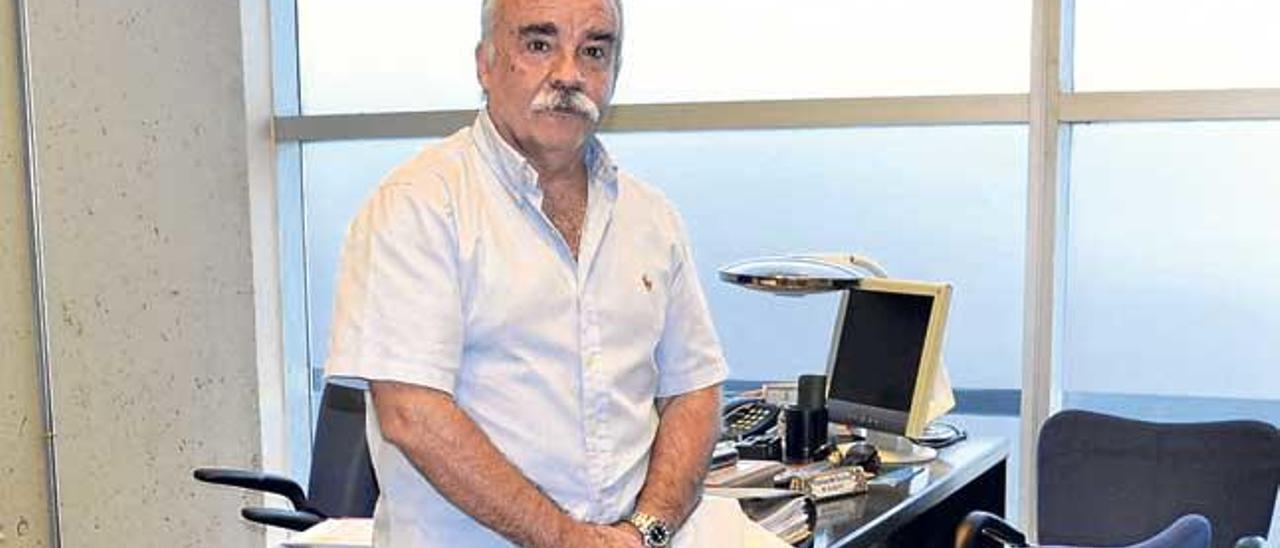 El banquero ya jubilado Juan Luis Solano posa sobre la mesa presidencial en la que ha estado 32 años ejerciendo.
