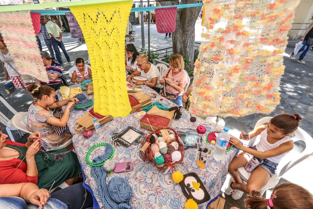 Un grupo de mujeres enseña en plena plaza de la Constitución de Almoradí las tradicionales labores de tejer y bordar para mantener la tradición