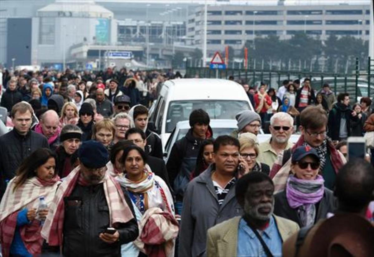 Una muchedumbre de pasajeros sale del aeropuerto de Bruselas .