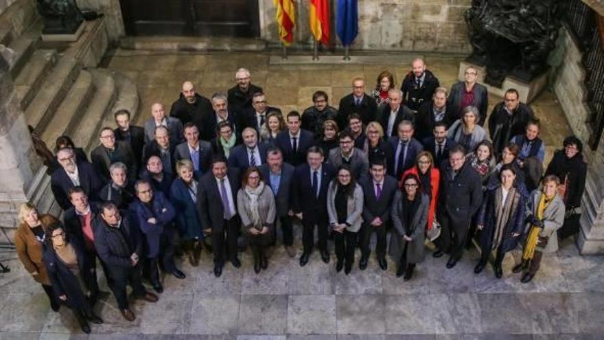 Sánchez con el ministro y, abajo, foto de familia en el Palau sin él tras presentarse el Fondo de Cooperación un día antes.