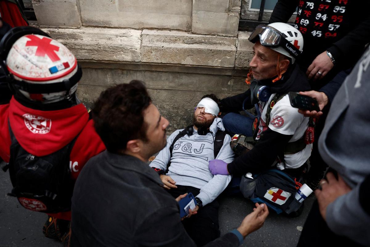 Médicos atienden al periodista lesionado Zakaria Abdelkafi durante los enfrentamientos en una manifestación en París.