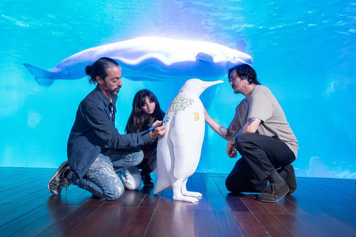 Pedro Mecinas, Nuria Bellver de Cachetejack y el artista de Groc pintando una escultura de pingüinos en la presentación del OceanFest