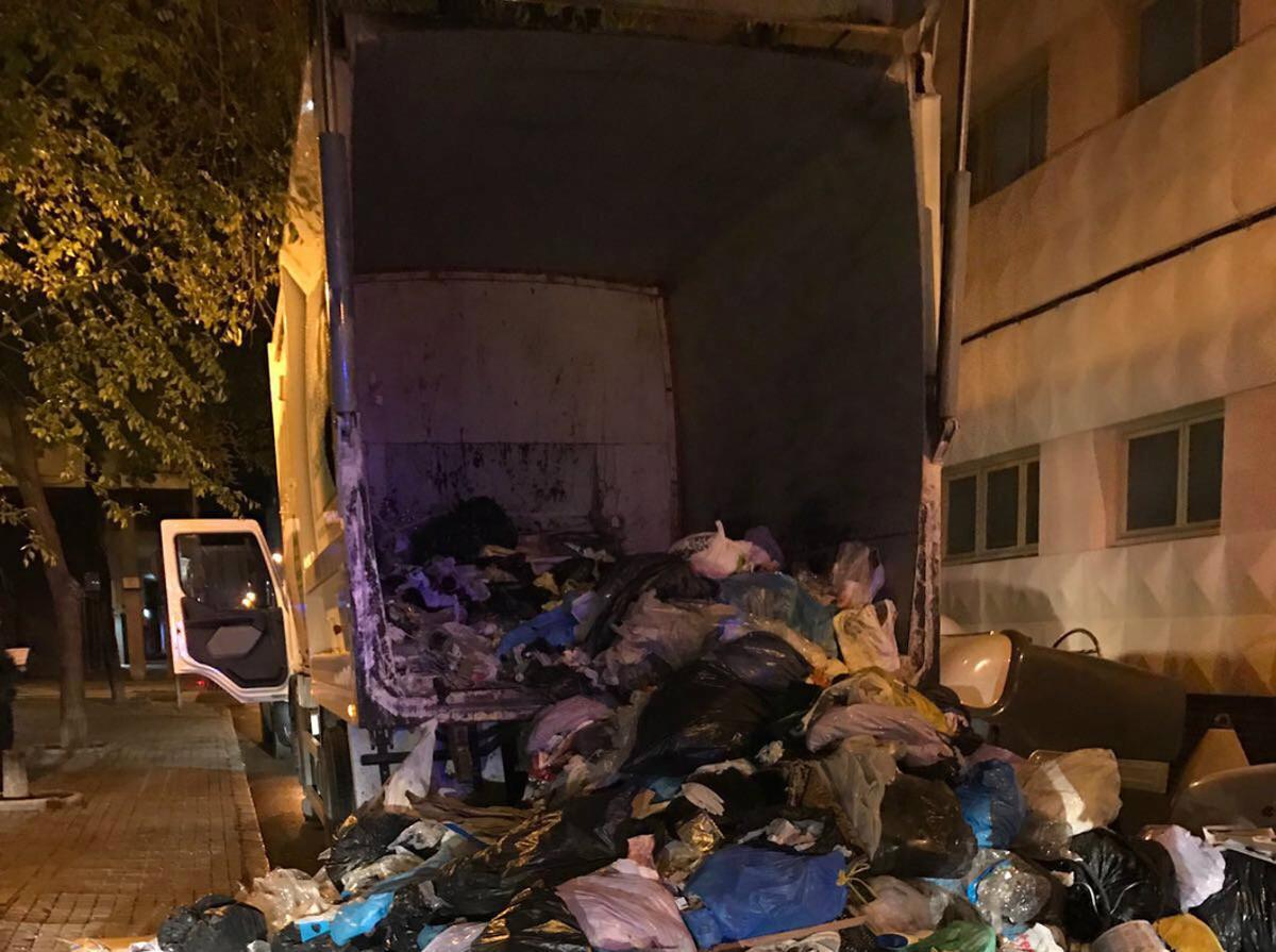 El camió d’escombraries on va ser trobat l’intrús, amb tota la càrrega escampada pel carrer.