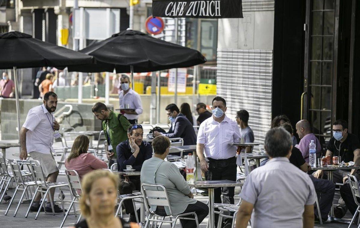 Clientes en la terraza del Café Zurich, en la plaza de Catalunya.