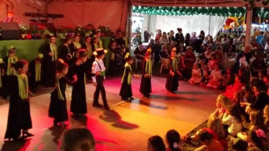 Varios niños de la escuela de sevillanas bailando.