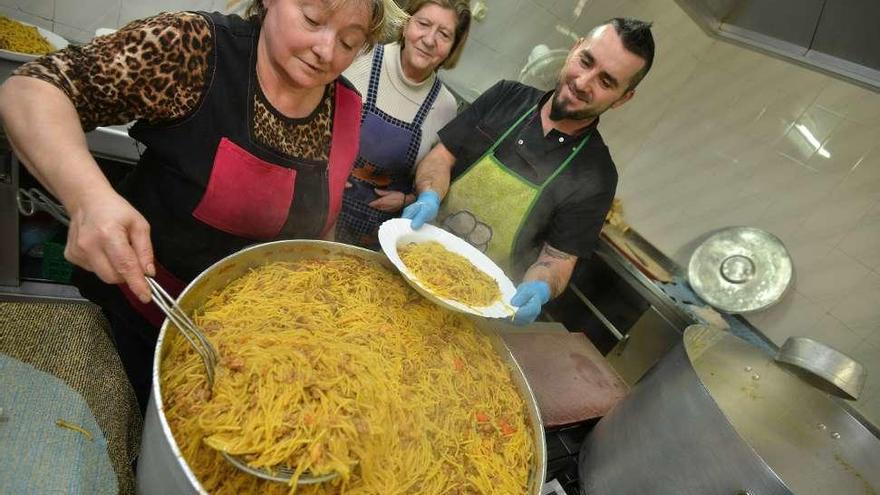 La cocinera prepara fideos con carne, una de las especialidades de la fiesta. // G. Santos