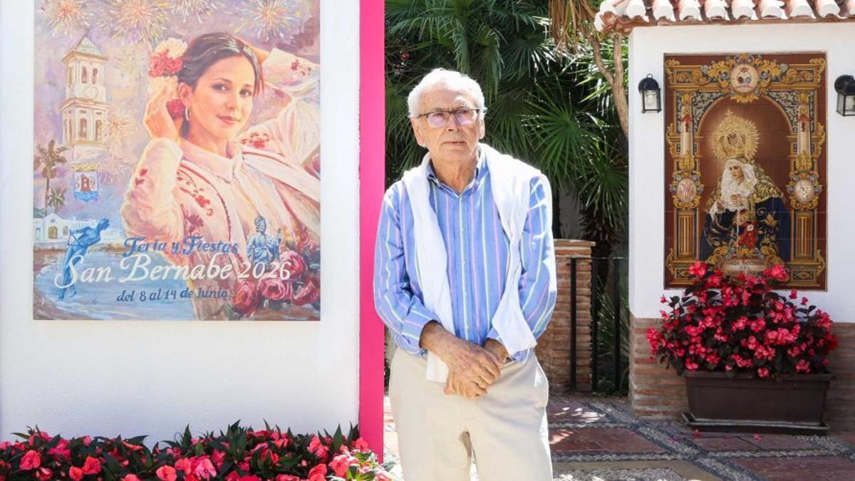 El autor malagueño, junto al cartel anunciador de la feria.