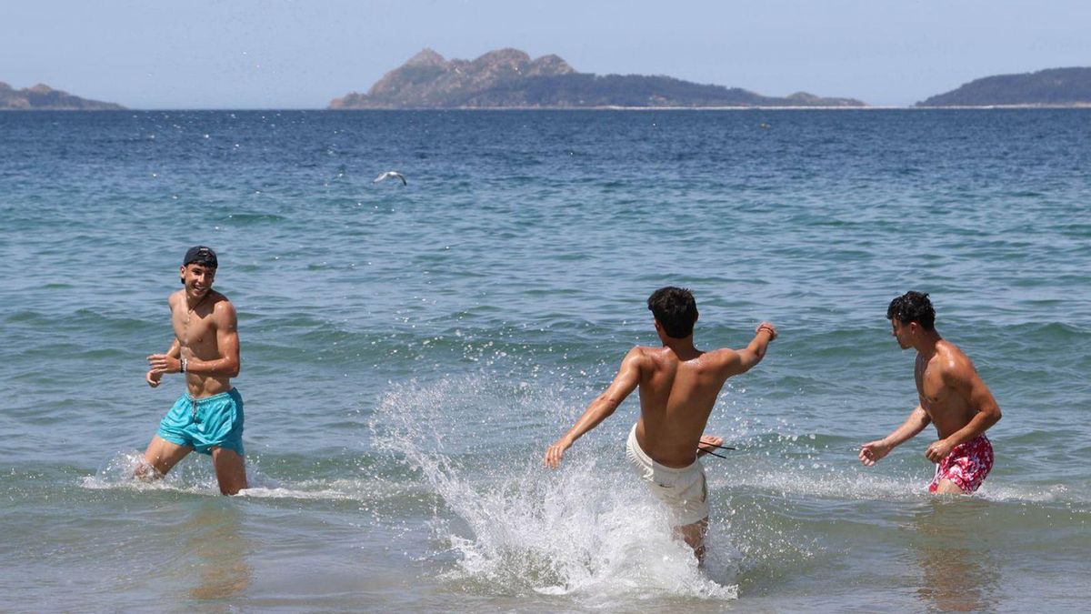 Tres jóvenes, disfrutando de un baño, ayer, en la playa de Samil.
