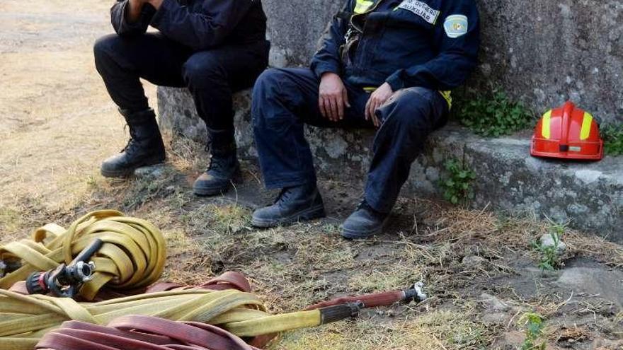 Dos bomberos, durante un descanso en el trabajo de extinción.