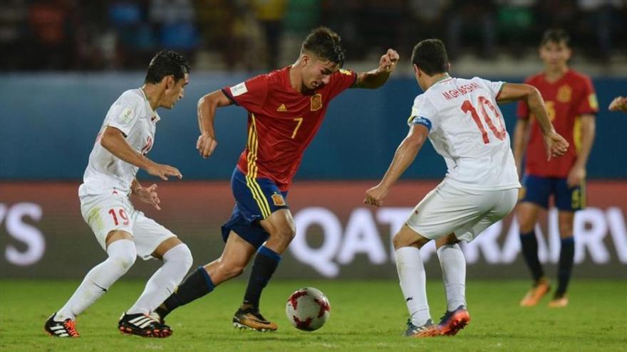 El valencianista Ferran Torres conduce la pelota ante un jugador rival, en plena acción.