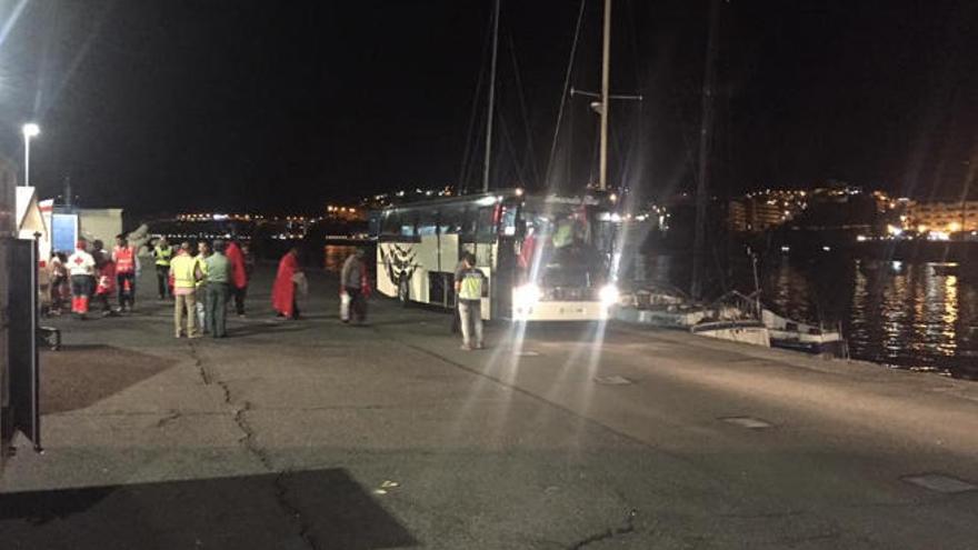 Algunos de los inmigrantes rescatados, al subir a la guagua durante la madrugada de ayer en Arguineguín.