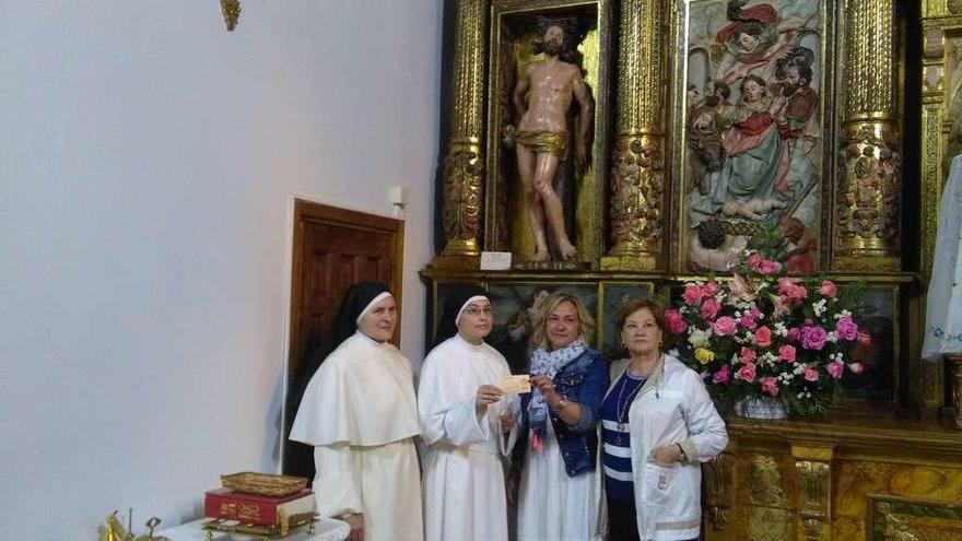 Religiosas del convento y las ganadoras de la mantelería posan junto a la escultura de Ducete.