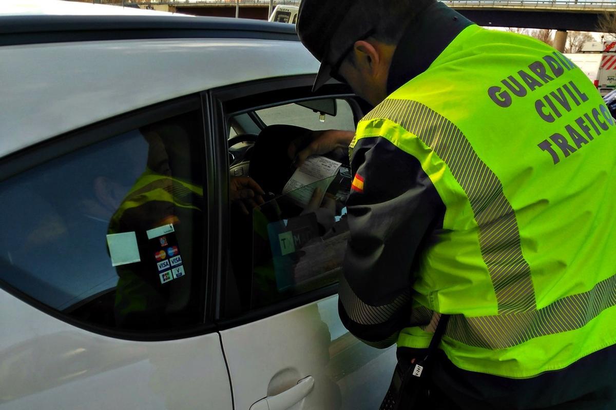 Un agente de la Guardia Civil de Tráfico durante un control de alcoholemia a un taxista.