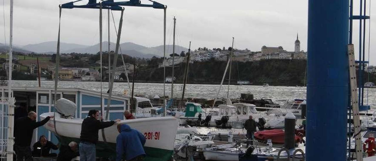 Usuarios del puerto de Figueras sacando a tierra embarcaciones.