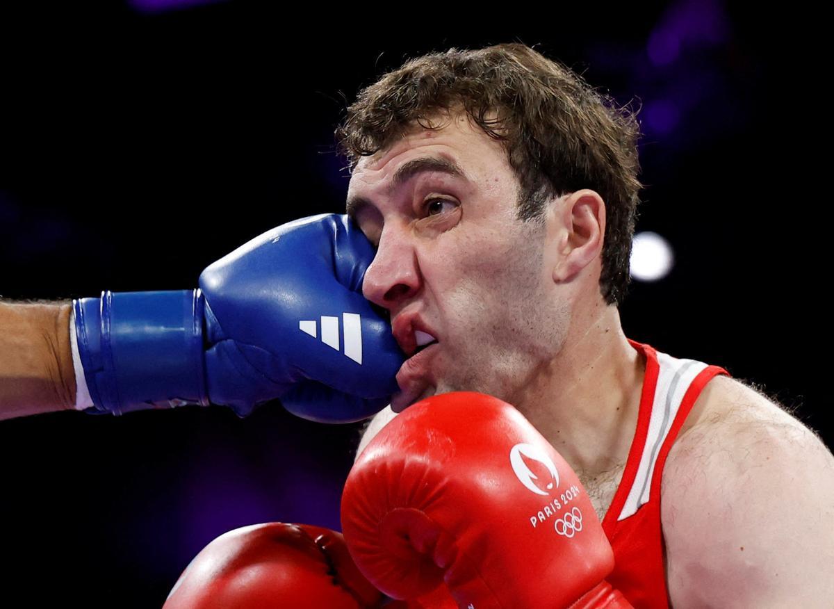 El armenio Davit Chaloyan recibe un golpe durante su combate de octavos de final de la competición de boxeo en la categoría de +92 kg