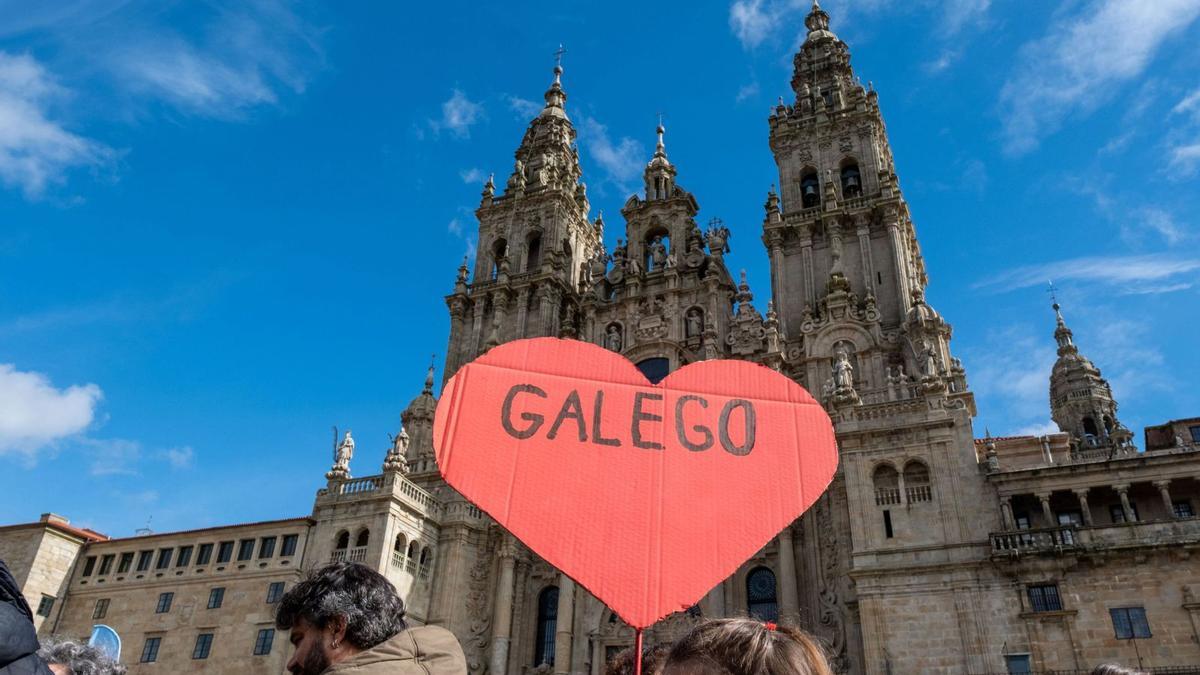 Manifestantes no Obradoiro cunha pancarta en defensa do galego.