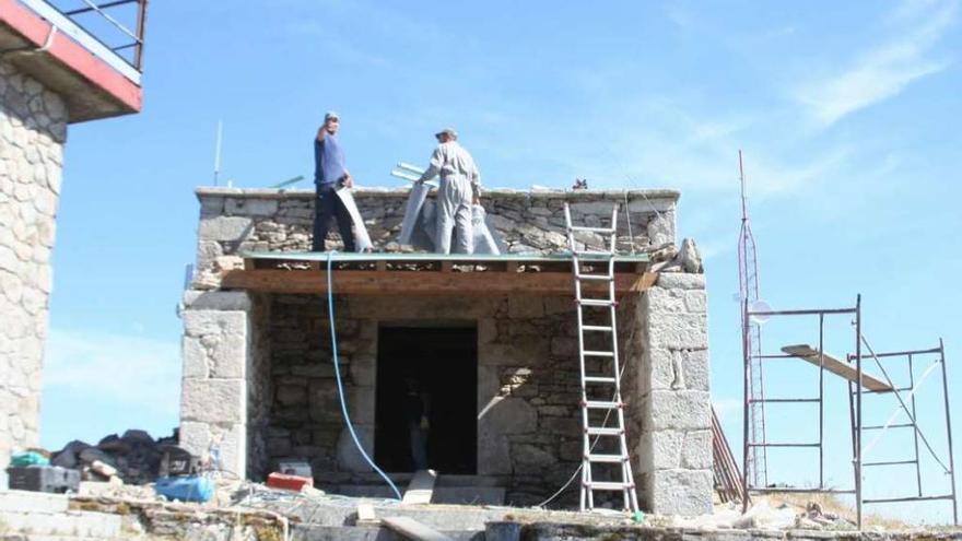 Obreros trabajando en la restauración de la capilla de San Sebastián en la parroquia de Moalde. // Bernabé