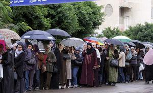 Un grup de dones, sota els seus paraigües, es resguarden de la pluja mentre fan cua per votar a Alexandria, Egipte.