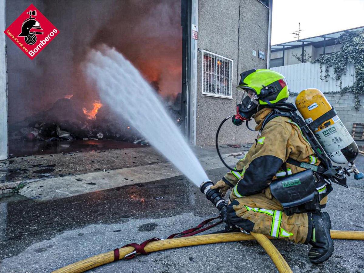 Un bombero trabajando en la extinción de las llamas, ya después de haber amanecido.