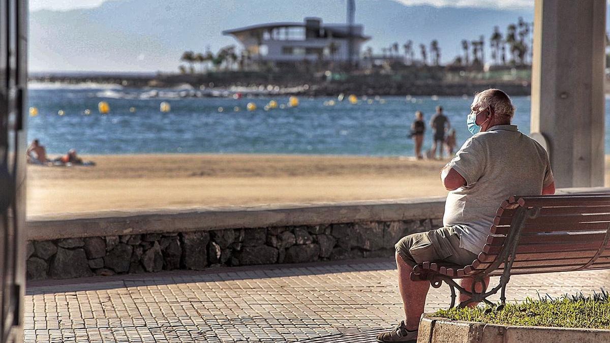 Un turista observa el mar en el paseo marítimo de Los Cristianos.