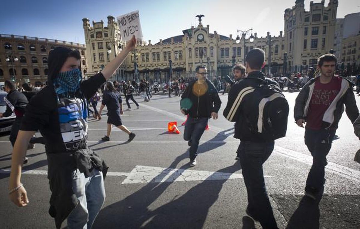 Un manifestant aguanta una pancarta al davant de l’estació de trens de València.