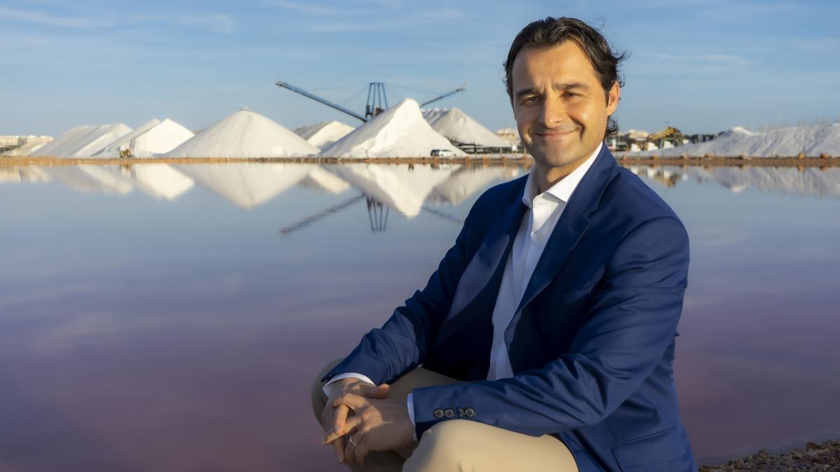 Eduardo Dolón posa con el fondo de las montañas de sal y la laguna rosa de Torrevieja. | INFORMACIÓN