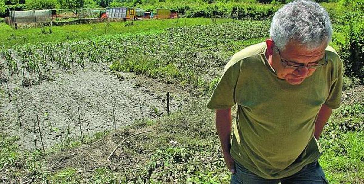 El agricultor José Santos, ante su finca, completamente destrozada por la fuerza de la riada, en Las Caldas (Oviedo).