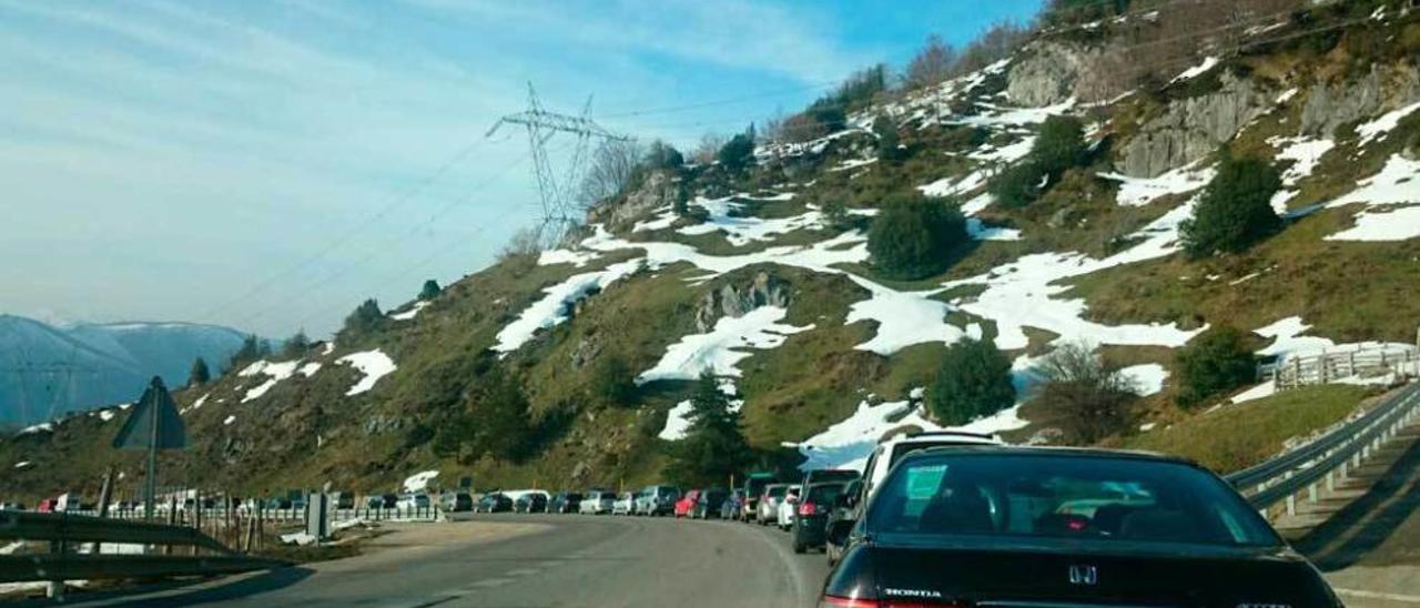 Arriba, un atasco en Pajares durante la temporada. A la izquierda, operarios trabajando en la obra.