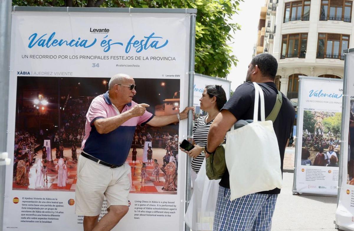 Un ciudadano valenciano explica aspectos de las fiestas a una pareja nicaragüense.  | J.M. LÓPEZ