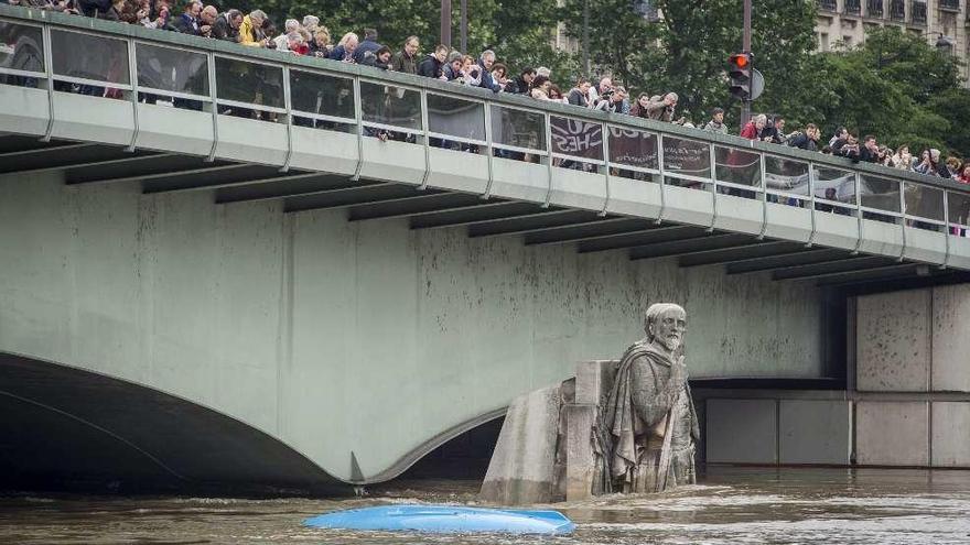 Parisinos hacen fotos del Sena rebosante.