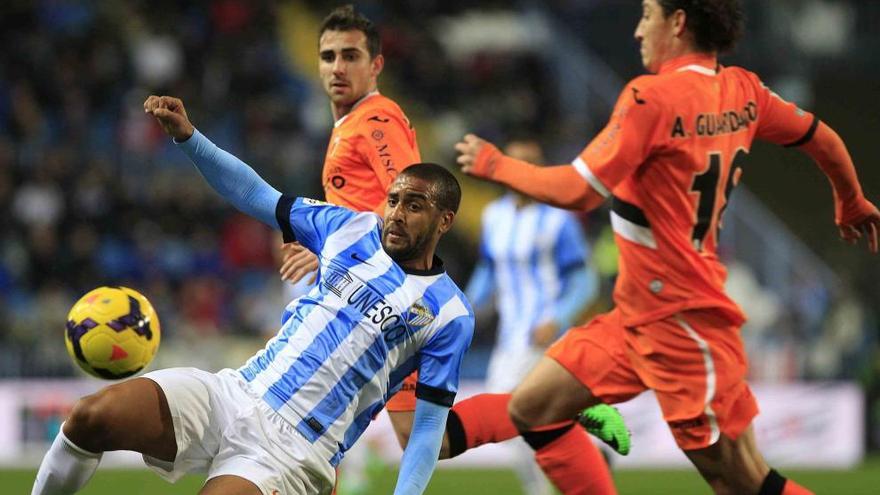 El centrocampista argentino del Málaga CF, Fernando Damián Tissone (i), cae ante los jugadores del Valencia CF, el delantero Alcácer García (atrás) y el centrocampista mexicano José Andrés Guardado (d), durante el partido.