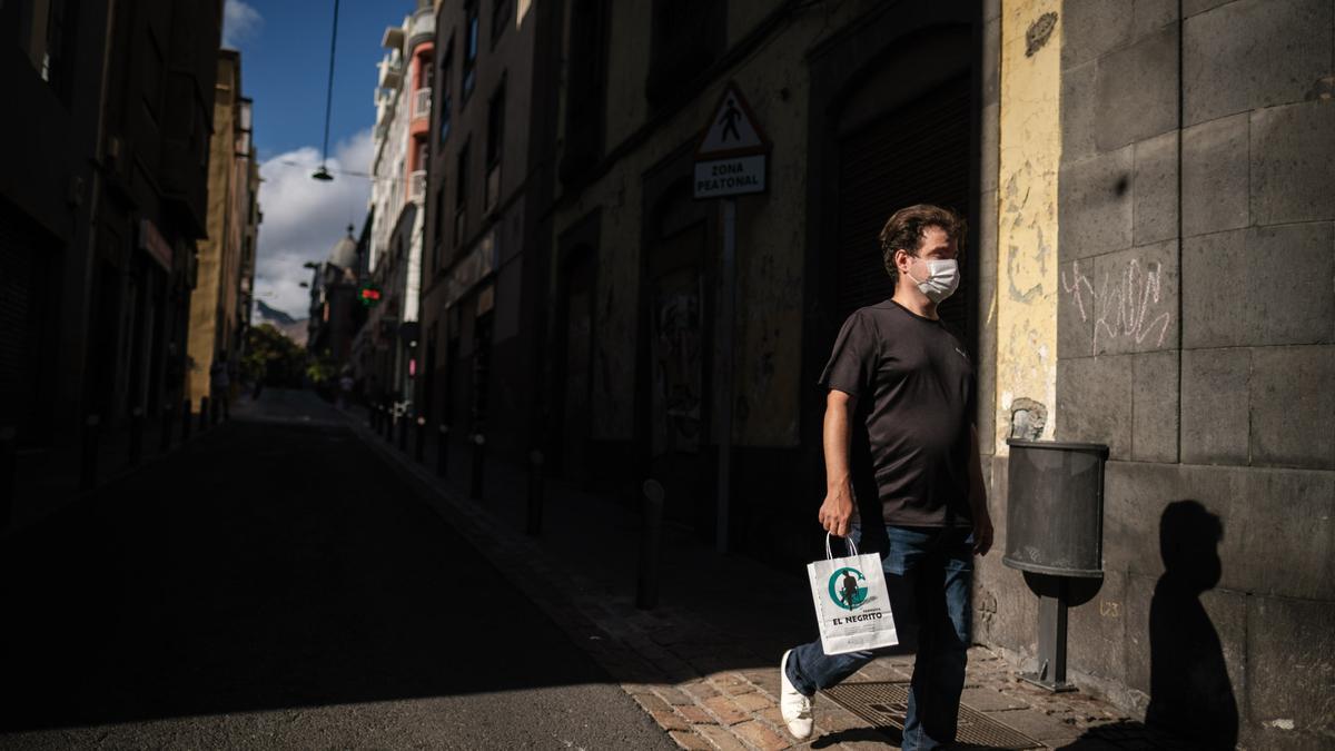 Un chico con mascarilla pasea por Santa Cruz de Tenerife.