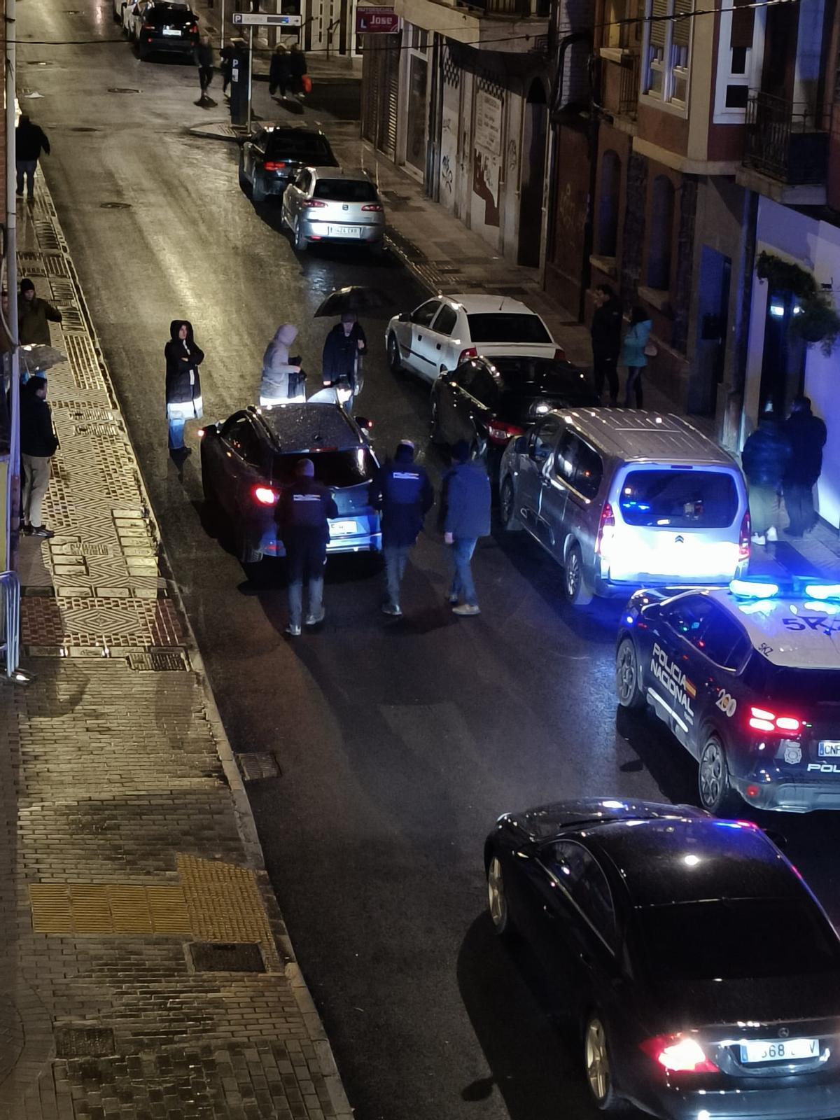 Varios vecinos, intentando traquilizar a la mujer en plena calle.