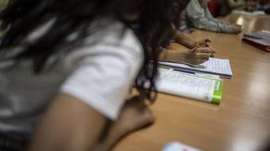 Dos alumnos realizan sus deberes en el aula.