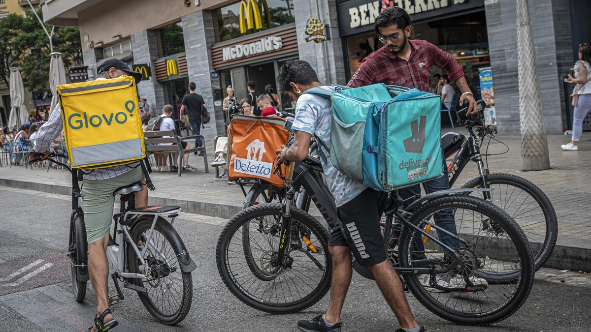 Repartidores de varias plataformas digitales se concentran frente a restaurantes de comida rápida para esperar sus pedidos.