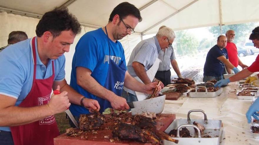 El carnicero Roberto Fanjul, segundo por la izquierda, despieza las patas de cordero, ayer, en Argüelles.