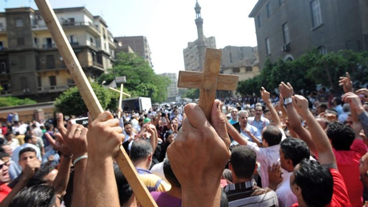 Centenares de personas protestan durante el funeral por los coptos fallecidos el domingo en los choques contra militares en el centro de El Cairo.