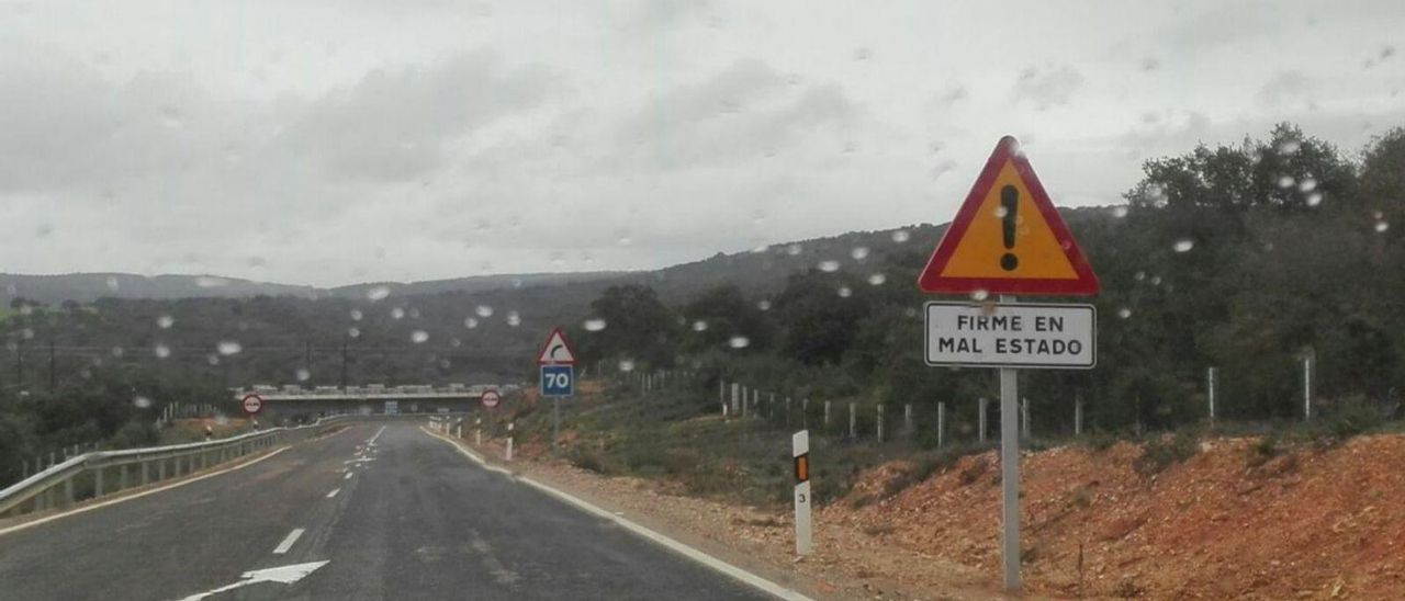 Señal que advierte del firme en mal estado en la carretera nacional 631.