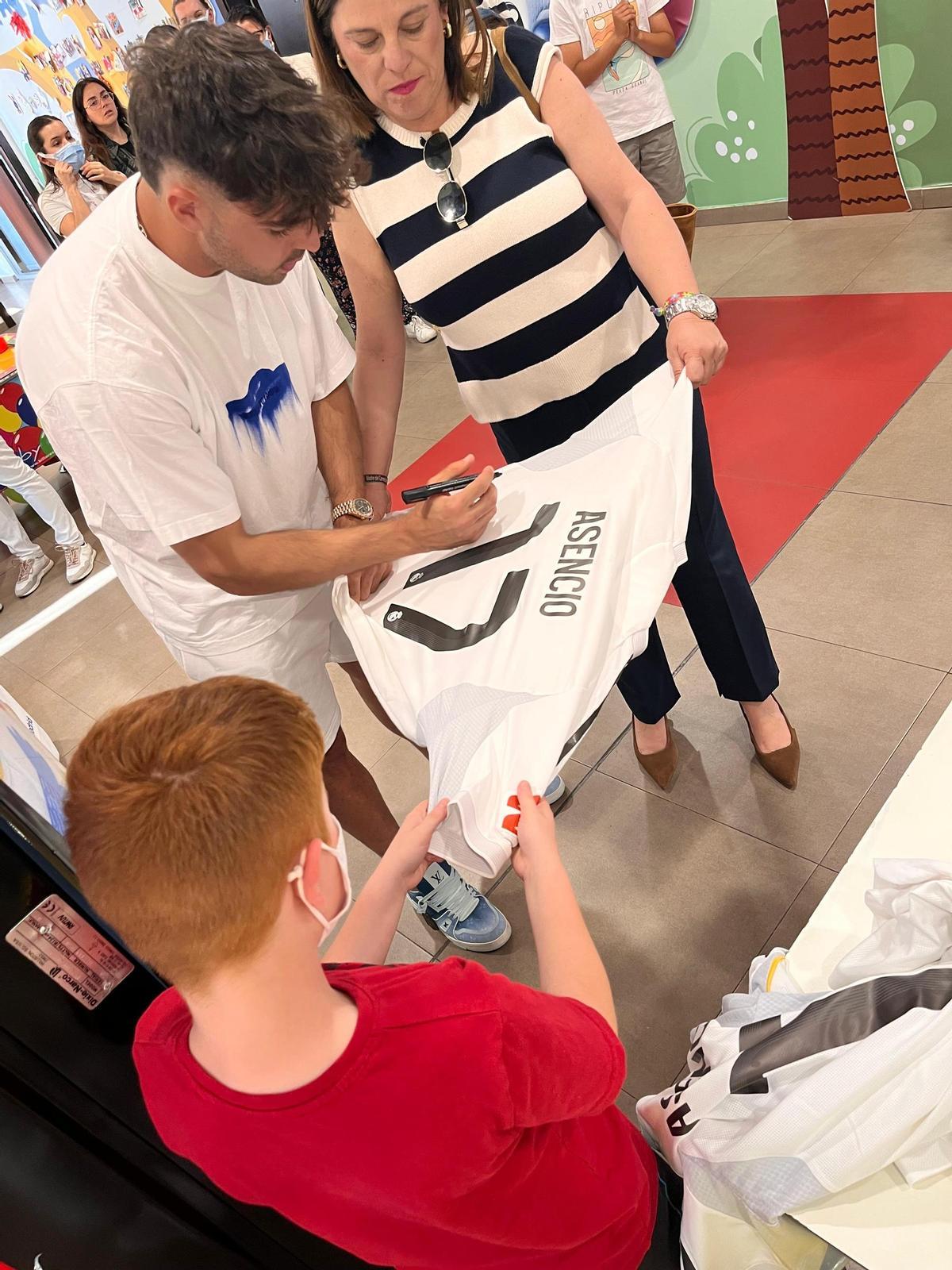 Raúl Asencio firma una de las camisetas que entregó a los niños alojados en la Casa Ronald de Madrid durante su visita solidaria