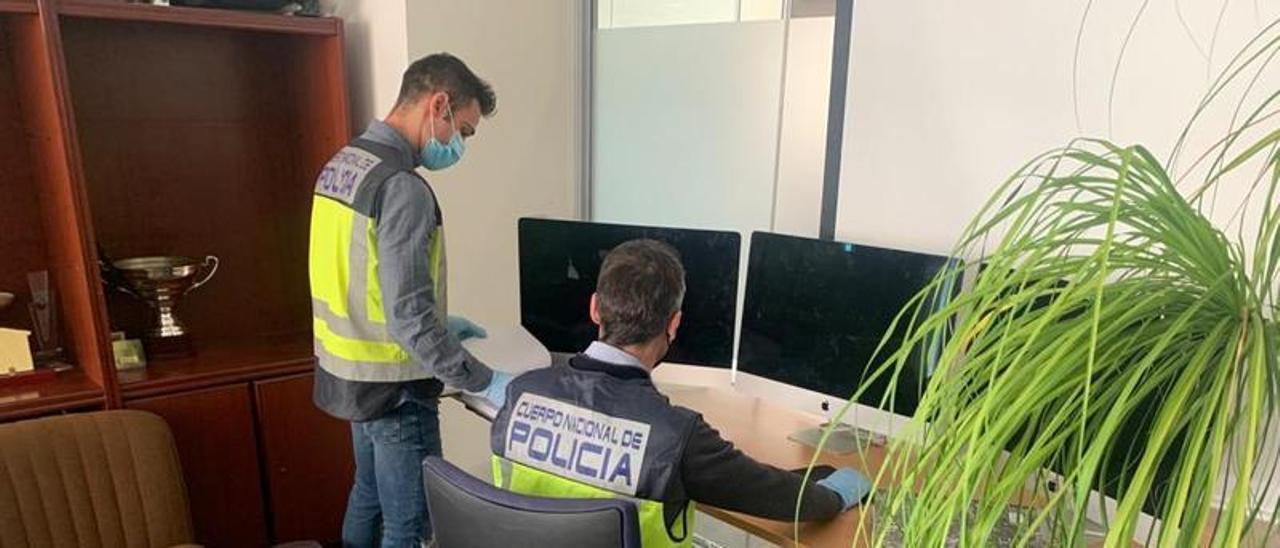 Agentes de la Policía Nacional durante el registro en la sede de la empresa por la presunta estafa de bitcoins.