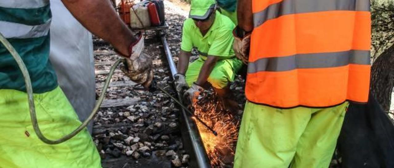 Operarios aplicando soldaduras en las vías durante los trabajos que afectan a la línea.