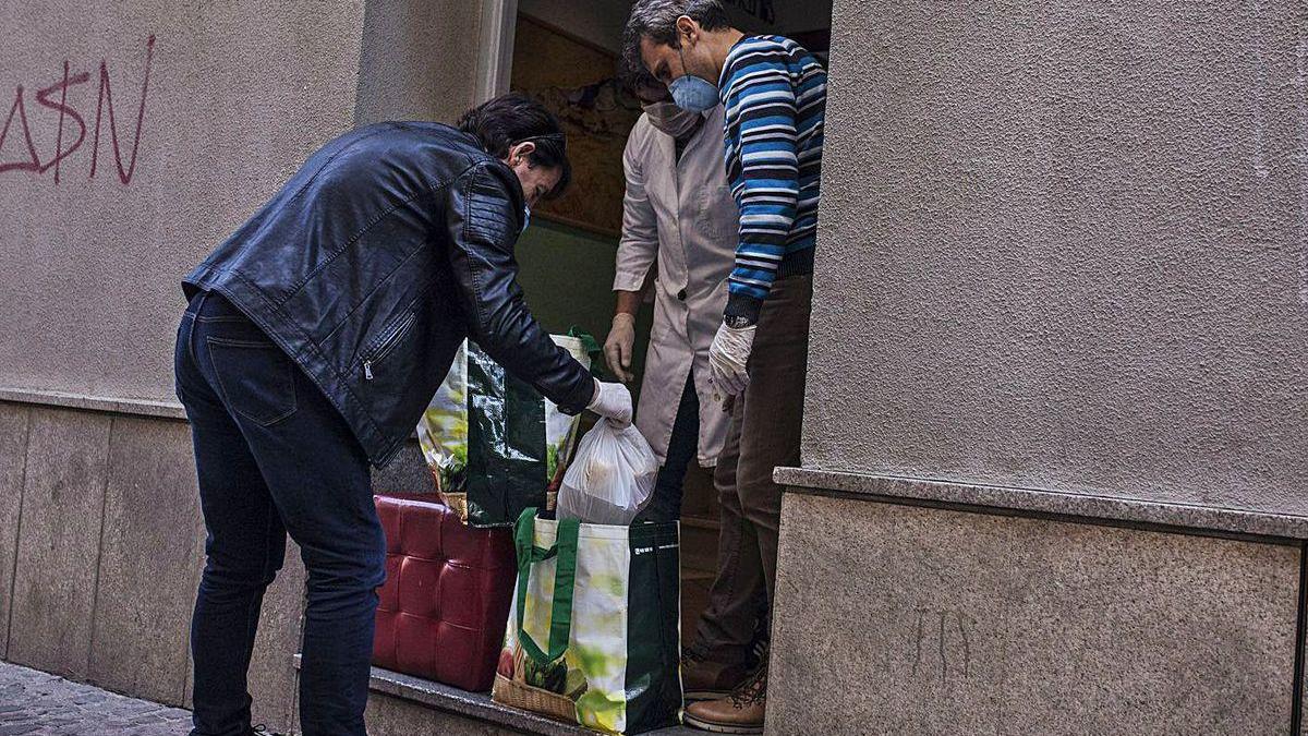 Entrega de comida a un ciudadano en el centro de acogida de Cáritas.