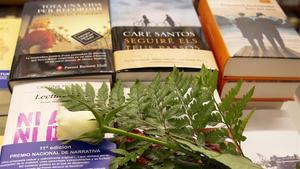 Una rosa blanca, símbolo este año de esperanza, homenaje a los sanitarios y recuerdo a las víctimas del covid, rodeada de libros, en la librería Laie de Barcelona, este martes.